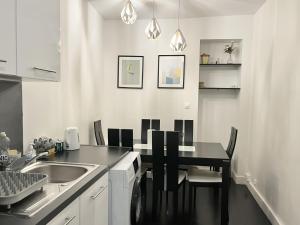 a kitchen with a black table and chairs and a sink at 80 m2-Heart of Le Marais -Sleeps 6 in Paris +23 photos