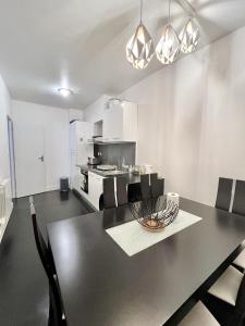 a kitchen and dining room with a black table and chairs at 80 m2-Heart of Le Marais -Sleeps 6 in Paris