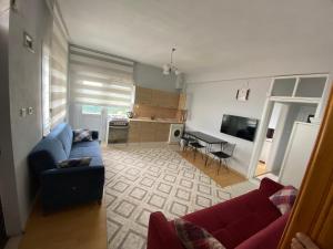 a living room with a blue couch and a kitchen at Özçelik Apart in Çaykara
