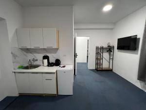 a kitchen with white cabinets and a sink at Urban Heart Residence in Sarajevo