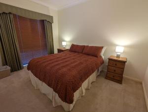 a bedroom with a bed and a window and two lamps at Unit in Hovell Street in Yarrawonga