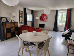 a living room with a table and a red couch at Gîte Les Gorges du Tarn in La Cresse