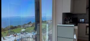 a kitchen with a large window with a view of the ocean at Hendre Coed Isaf Caravan Park in Barmouth