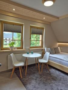 una stanza con un letto, un tavolo e delle sedie di Kozie Turnie a Poronin