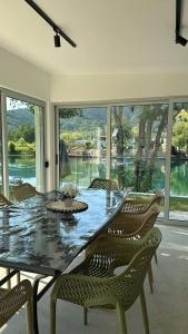 a dining room table and chairs with a view of the water at Villa L&M in Bihać