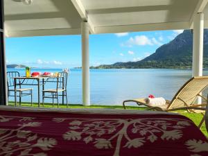 a porch with a table and chairs and a view of the water at Lagoon house between sea and mountain, near Vaitape and Matira in Bora Bora