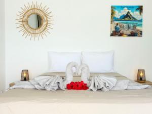 a bedroom with a bed with two towels and a mirror at Lagoon house between sea and mountain, near Vaitape and Matira in Bora Bora