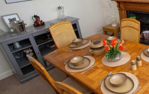 ein Esstisch mit Hüten und Blumen darauf in der Unterkunft Comfortable Home near NEC, BHX in Birmingham + 39 Fotos