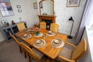 ein Esszimmer mit einem Holztisch und Stühlen in der Unterkunft Comfortable Home near NEC, BHX in Birmingham