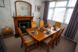 ein Esszimmer mit Tisch und Stühlen und einem Kamin in der Unterkunft Comfortable Home near NEC, BHX in Birmingham