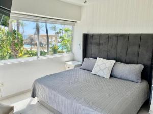 Un dormitorio con una cama con una ventana grande. en FRENTE AL MAR A PIE DE PLAYA ALBERCA y JACUZZI, en La Florida 14 fotos más