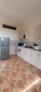 a kitchen with white cabinets and a wooden floor at Hospedaje Dase in Oxapampa