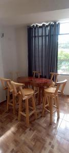 a room with wooden tables and chairs and a window at Hospedaje Dase in Oxapampa +4 photos