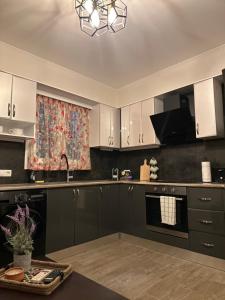 a kitchen with black and white cabinets and a window at AlexandRos Home in Áyioi Dhéka