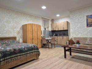 a bedroom with a bed and a kitchen with a table at GreenSilence in Mtskheta
