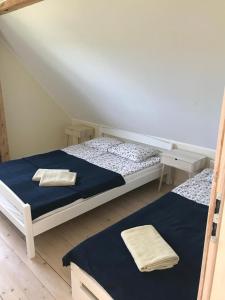 a bedroom with two beds in a room at Apartamenty Dom Ogrodnika in Białogóra +3 photos