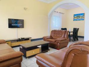 a living room with leather furniture and a flat screen tv at ELG Appart in Kribi