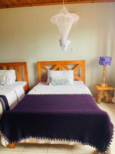 a bedroom with a bed with a purple blanket at LAVENDER Residence Arusha in Arusha +10 photos