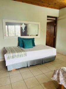a bedroom with a large bed with blue pillows at LAVENDER Residence Arusha in Arusha