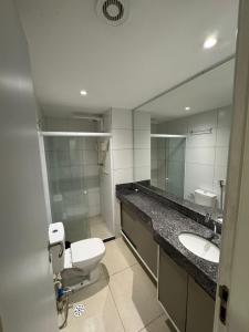 a bathroom with a toilet and a sink and a mirror at Flat beira mar Olinda Empresarial Jam in Olinda