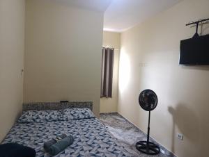 a bedroom with a bed and a fan at Hotel Atalaia in Vitória da Conquista +3 photos