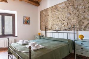 a bedroom with a bed and a stone wall at Libera Mente in Fabriano