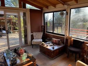 un soggiorno con tavolo, sedia e finestre di Hotel Boutique Valle la ligua casa de campo a El Cerrillo