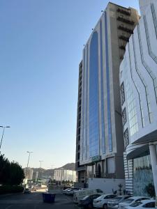 a large building with cars parked in a parking lot at فندق اسفار الحجاز 2 in Al Masfalah