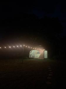 a greenhouse in a field at night with lights at Glamping Lily in San Rafael