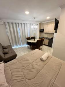 a bedroom with a bed and a dining room at Tres Fronteras Apart 3 in Puerto Iguazú