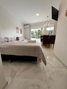a bedroom with a large bed and a dining room at Tres Fronteras Apart 3 in Puerto Iguazú +16 photos