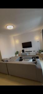 a living room with a couch and a flat screen tv at jotapecomercio in Praia +1 photo
