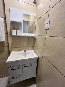 a bathroom with a sink and a mirror at Tres Fronteras Apart 3 in Puerto Iguazú