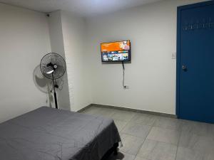 a bedroom with a fan and a tv on the wall at Coliving habitacional in Cali