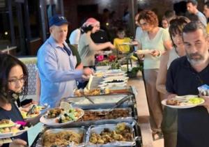 a group of people standing around a buffet of food at Rum Sky Experiences in Wadi Rum