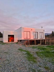 a home with a large metal building on a field at Cabaña Viaducto Vista al Mar, Curanipe in Pelluhue