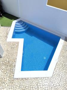 ein blauer Swimmingpool mit einer Treppe in einem Gebäude in der Unterkunft BEAUTIFUL VILLA - 4 bedrooms, heated pool, 2 priv car park places, fibre net, PS5, tv channels in Adeje