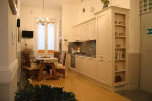 ローマにあるSilver Fernの白いキャビネットとテーブル付きのキッチンが備わります。