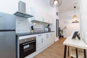 a kitchen with white cabinets and a stove top oven at Quiet & Modern Apartment in Valencia