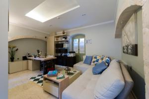 フィスカルドにあるFiscardonna Luxury Suitesのリビングルーム(白いソファ、テーブル付)