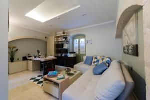 a living room with a white couch and a table at Fiscardonna Luxury Suites in Fiskardo