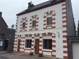 an old white and red building with a door at Number 7 Gouarec in Gouarec
