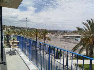 a balcony with a blue fence and palm trees at Fronteporto in Porto Empedocle