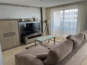 Playa de GandiaにあるApartamento El Eden Playa de Gandíaのソファとテレビのあるリビングルーム