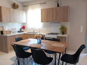 a kitchen with a wooden table and chairs at Village House in Ágios Matthaíos