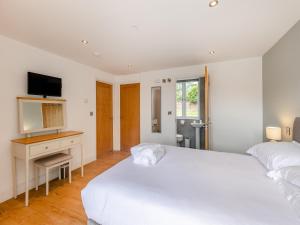 a white bedroom with two beds and a desk at Ty Godro - Uk12745 in Acrefair +18 photos