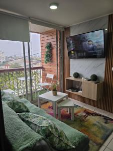 a living room with a couch and a flat screen tv at Espacio moderno y acogedor departamento en Rancagua in Rancagua