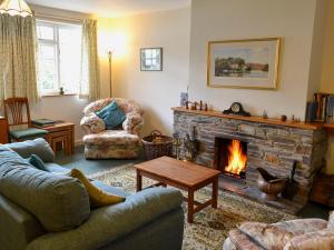 ein Wohnzimmer mit Couch und Kamin in der Unterkunft Watercolour Cottage in Lerryn