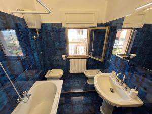 a blue tiled bathroom with two toilets and a sink at Casa RoSi in Torrevecchia Teatina +4 photos
