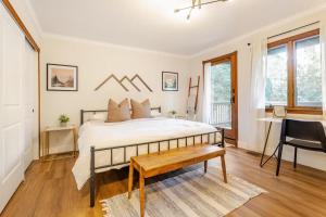 a bedroom with a bed and a desk and a chair at Sleeps 10 Cozy Modern Cabin- 5 minutes to lake, fishing, & hiking in Crestline